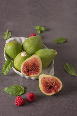 A close-up of assorted fresh figs and raspberry