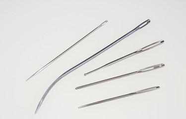metallic sewing needles at smooth surface