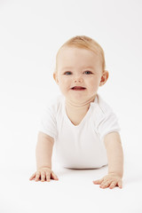 Young baby girl crawling on front, studio.