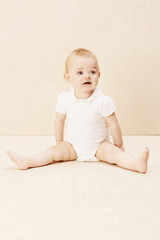 Fototapeta premium Baby girl looking up, studio shot.