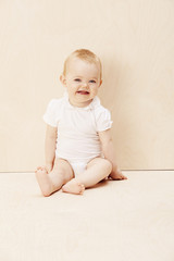 Fototapeta premium Baby girl looking up, studio shot.