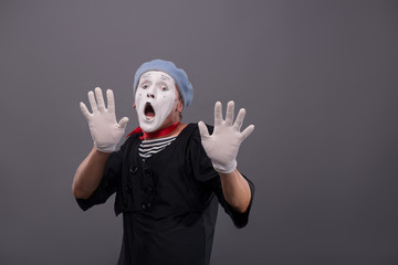 Portrait of young mime boy showing something with his hands