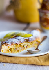 strudel dessert with pears on a white plate, .yellow, closeup