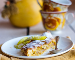 strudel dessert with pears on a white plate, .yellow napkin