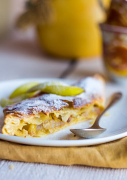 strudel dessert with pears on a white plate, .yellow, closeup