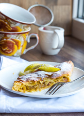 strudel dessert with pears on a white plate, vertically