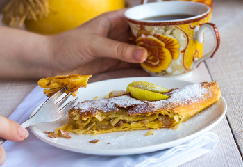eat apple strudel on a white plate, hands