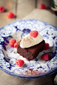 Brownies with raspberry on a wooden background.