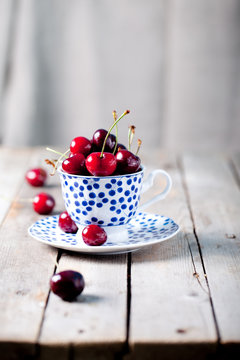 Fresh cherry in a blue ceramic cup