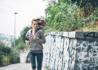 Fototapeta premium Fitness young woman jogging in the city park