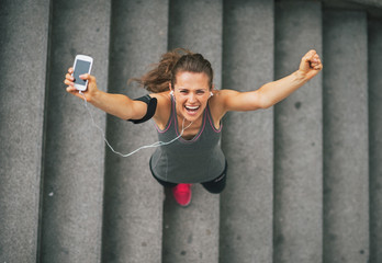 Portrait of happy fitness young woman with cell phone 