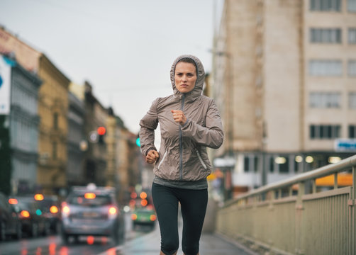 Fitness Young Woman Jogging In Rainy City