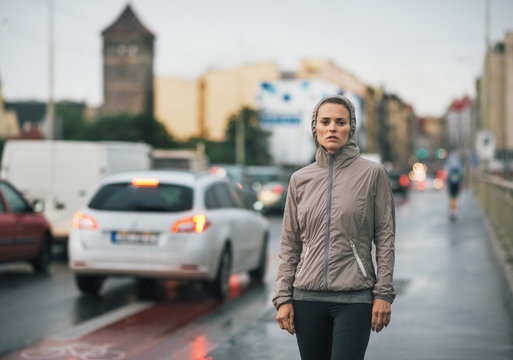 Portrait of fitness young woman in rainy city