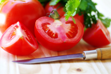 ripe tomato sliced  and knife on table
