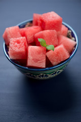 Close-up of a ceramic bowl with watermelon cubes, vertical shot