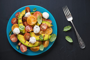 Vegetable salad with grilled avocado and basil, above view