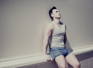 Obraz premium Handsome man resting after training listening to music on headph