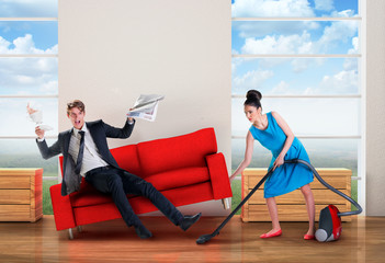 Angry woman vacuuming while man is resting