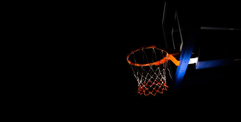 Fototapeta na wymiar Basketball hoop on black background with light effect