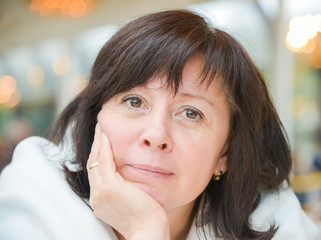 middle-aged woman brown eyes is sitting in the apartment