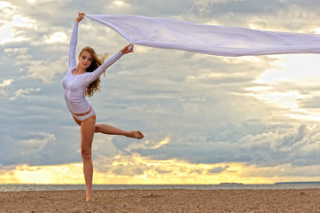Fototapeta na wymiar Beautiful ballerina dancing at the sea beach.