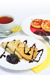 Food of Crepes, cheesecakes with berry sause and cup of tee.