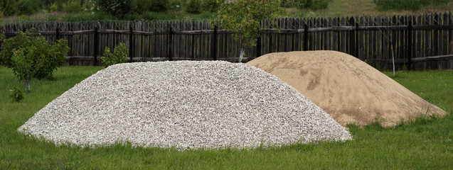 Heaps of sand and broken stone on the grass
