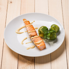 Baked trout with sauce and broccoli