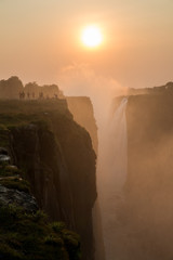 Victoria Falls sunset with tourist in the cliff