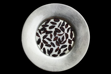 Dried zwetschke plums on silver plate still life.