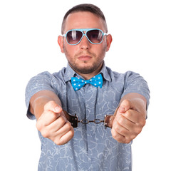 Adult male with beard in a blue bow tie  in police handcuffs