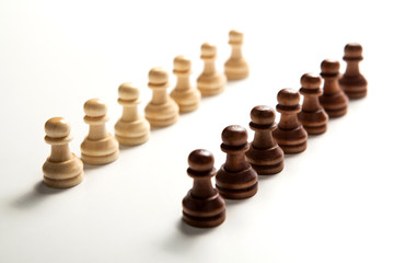 chess pieces lined up in a row on a white