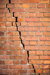 The wall of the old red brick with a crack across the wall