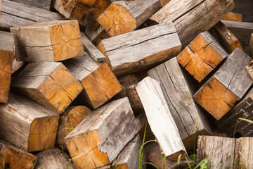 chaotic pile of firewood logs lying on green grass