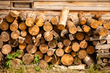 chaotic pile of firewood logs lying on green grass