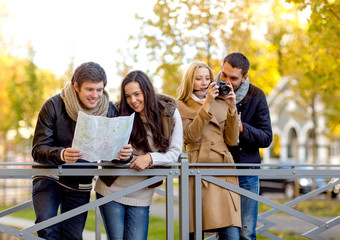 group of friends with map and camera outdoors