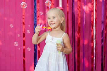 Happy little girl with soap bubbles