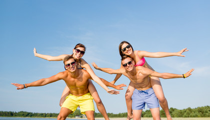 smiling friends having fun on summer beach