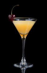 Yellow cocktail decorated with cherry in martini cocktails glass