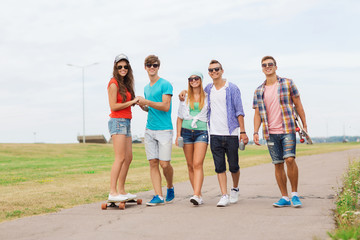 Obraz premium group of smiling teenagers with skateboards