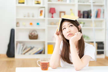 部屋で本を読む女性