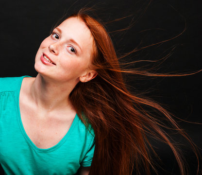 Young girl with flowing red hair on a black background