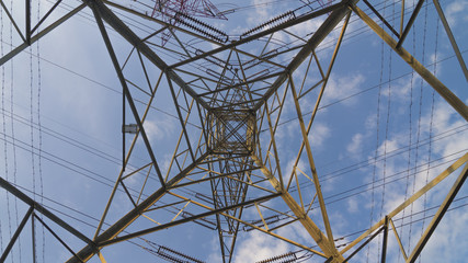 High power transmission towers against blue sky.