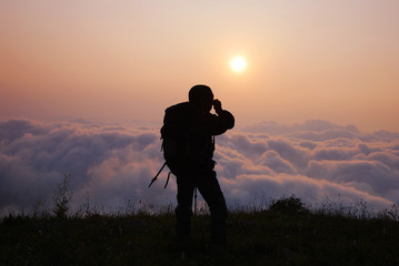 clouds and travelers in the mountains in the sunrise