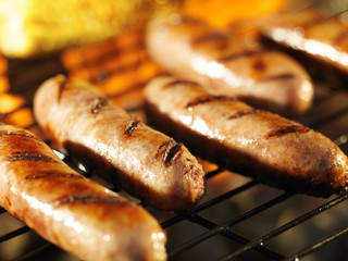 bratwursts on grill with corn close up