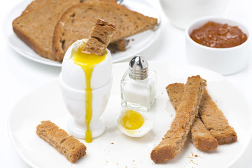 soft boiled egg, toasts and jam for breakfast, close-up