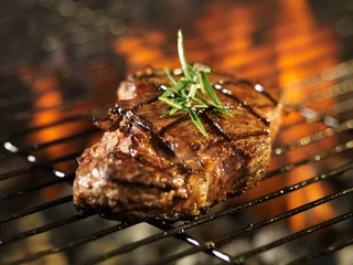 Crédence de cuisine en verre imprimé Grill / Barbecue steak cuit sur un gril flamboyant