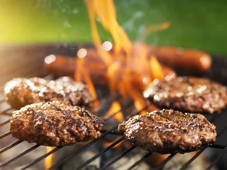  hamburgers en hotdogs koken op vlammende grill © Joshua Resnick