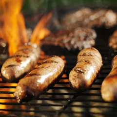  cooking bratwursts over flaming grill © Joshua Resnick