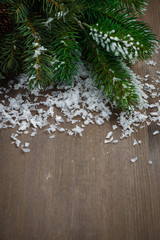 wooden background with fir branches and snow, top view, vertical